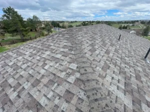 An image of a roof with visible hail damage (e.g., dents, cracked shingles) to illustrate what homeowners should look for.