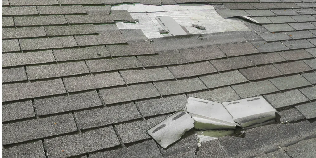 Roof with missing shingles caused by wind storm